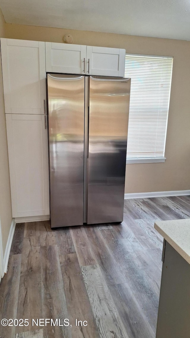 2756 Hidden Village Dr, Jacksonville, FL 32216 - kitchen with white cabinets, baseboards, freestanding refrigerator, wood finished floors, and light stone counters