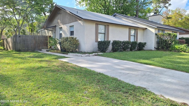 2756 Hidden Village Dr, Jacksonville, FL 32216 - view of side of property featuring a yard, stucco siding, and fence