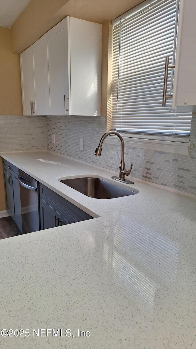 2756 Hidden Village Dr, Jacksonville, FL 32216 - kitchen with tasteful backsplash, blue cabinetry, white cabinets, dishwasher, and a sink