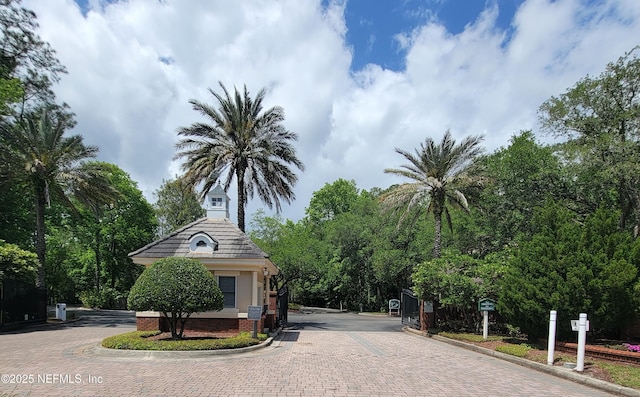 view of street featuring a gated entry and curbs