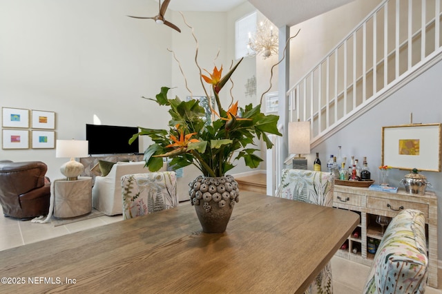 dining area with a ceiling fan, stairway, and tile patterned floors