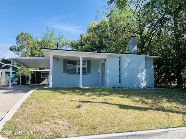 5133 Palmer Ave, Jacksonville, FL 32210 - view of front of home featuring concrete driveway, a front yard, stucco siding, and an attached carport