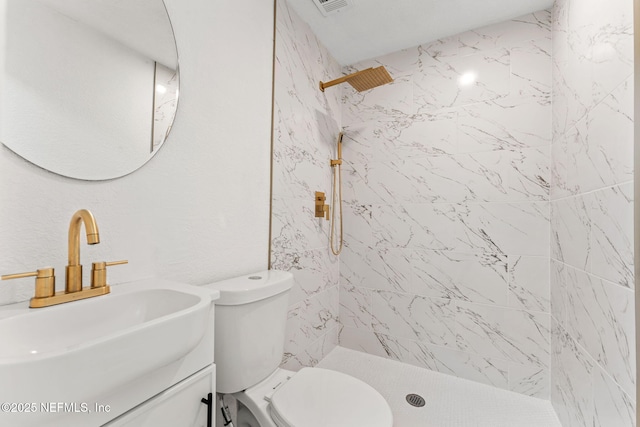 full bath with toilet, tiled shower, and vanity