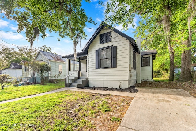 bungalow with a chimney, fence, and a front lawn