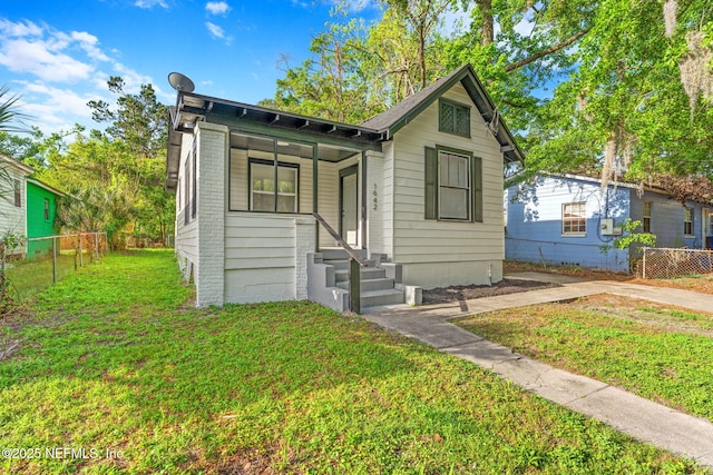 view of front of property featuring fence and a front lawn