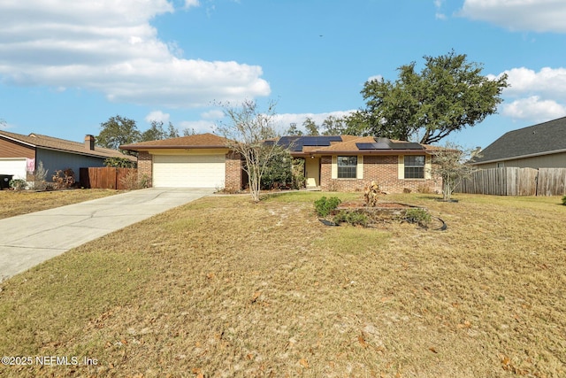 2566 Sandlewood Cir, Orange Park, FL 32065 - ranch-style house featuring an attached garage, a front yard, brick siding, fence, and roof mounted solar panels