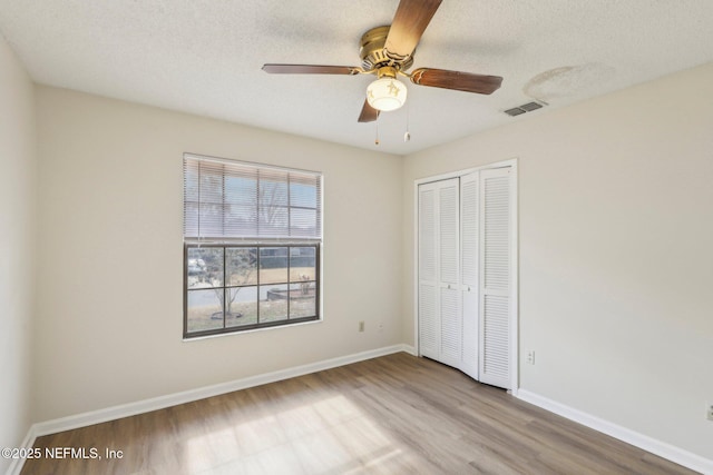 2566 Sandlewood Cir, Orange Park, FL 32065 - unfurnished bedroom with a closet, baseboards, a textured ceiling, visible vents, and wood finished floors