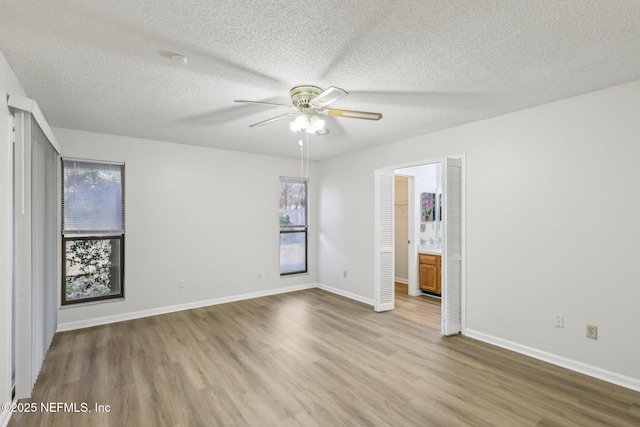 2566 Sandlewood Cir, Orange Park, FL 32065 - unfurnished bedroom featuring light wood finished floors, multiple windows, baseboards, and a textured ceiling
