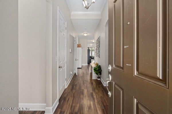 hallway with dark wood-style flooring, baseboards, and ornamental molding