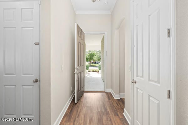 doorway to outside with dark wood-style floors, baseboards, and ornamental molding