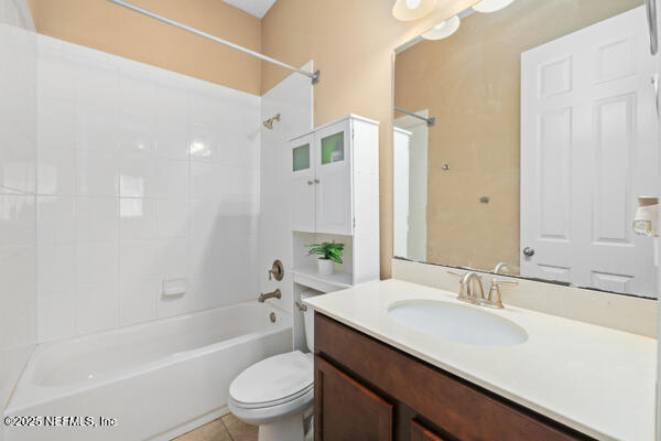 bathroom featuring tile patterned floors, toilet, shower / bathing tub combination, and vanity