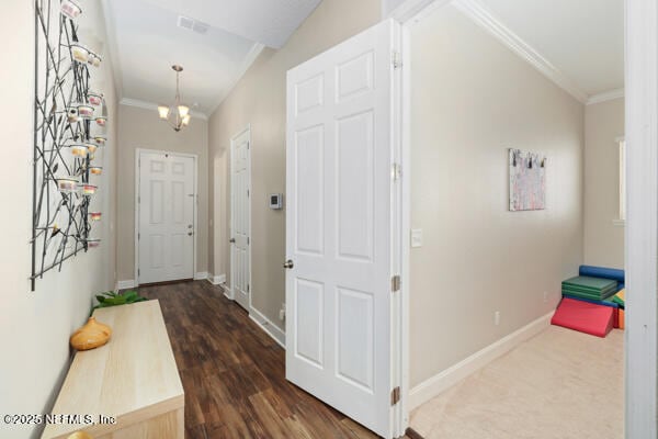hall featuring baseboards, ornamental molding, and visible vents