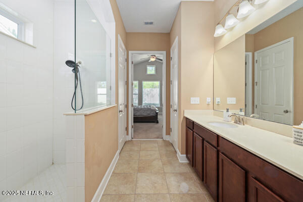 full bath with vanity, ensuite bath, walk in shower, a ceiling fan, and visible vents