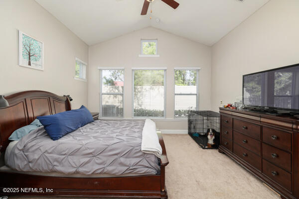 bedroom with light carpet, ceiling fan, and vaulted ceiling