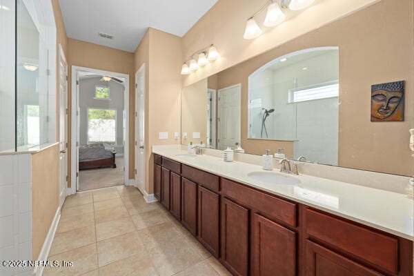 bathroom featuring tile patterned floors, double vanity, a sink, and a ceiling fan