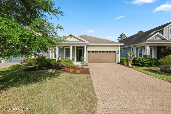 view of front of house with a garage, a front yard, and decorative driveway