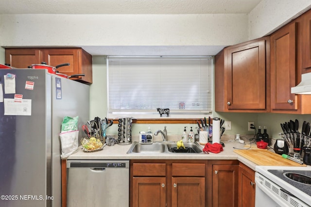 kitchen featuring a sink, light countertops, appliances with stainless steel finishes, under cabinet range hood, and brown cabinetry