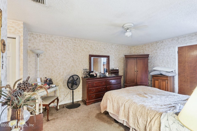 carpeted bedroom featuring visible vents, baseboards, a textured ceiling, and wallpapered walls