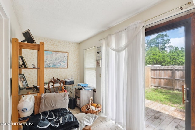 doorway featuring a textured ceiling, wallpapered walls, and light tile patterned floors