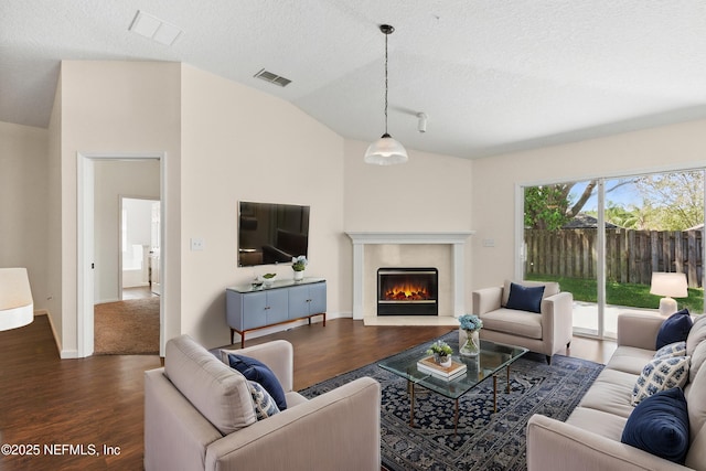 1217 Maclaren St, Saint Augustine, FL 32092 - living room featuring a textured ceiling, a fireplace, dark wood finished floors, and visible vents