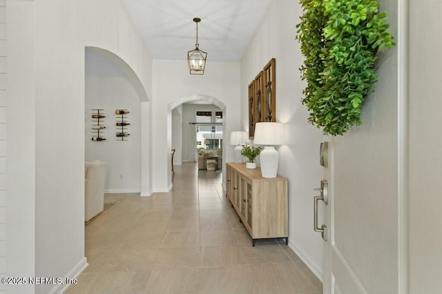 311 Wild Rose Dr, Saint Johns, FL 32259 - hallway featuring arched walkways, light tile patterned flooring, and baseboards