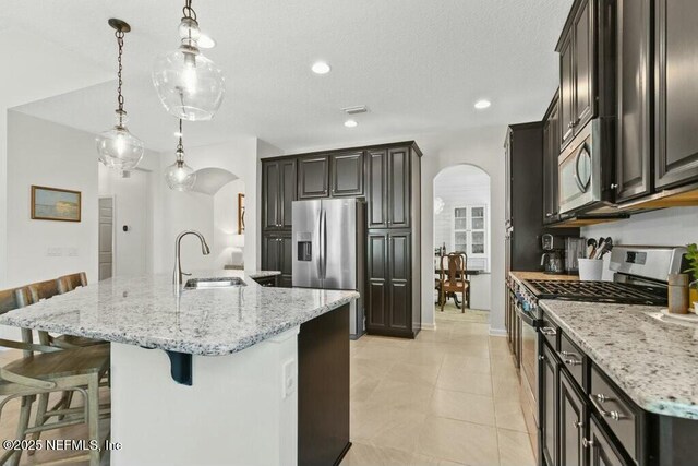 311 Wild Rose Dr, Saint Johns, FL 32259 - kitchen with arched walkways, a sink, a breakfast bar area, and stainless steel appliances