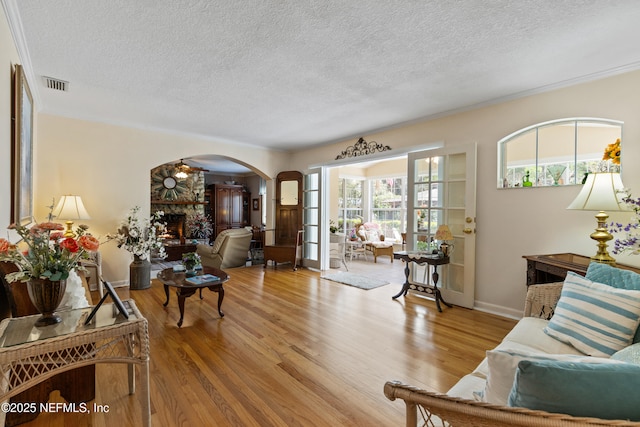 50 SE Forest St, Keystone Heights, FL 32656 - living area with arched walkways, wood finished floors, a fireplace, and visible vents