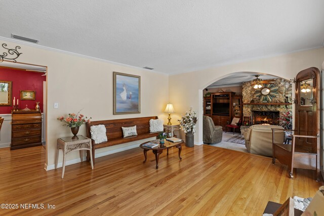 50 SE Forest St, Keystone Heights, FL 32656 - living area with visible vents, a stone fireplace, arched walkways, and light wood-style floors