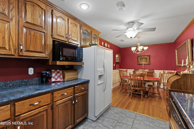 50 SE Forest St, Keystone Heights, FL 32656 - kitchen featuring white fridge with ice dispenser, ornamental molding, brown cabinetry, black microwave, and ceiling fan with notable chandelier