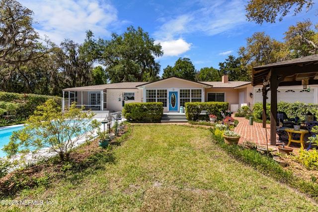 50 SE Forest St, Keystone Heights, FL 32656 - rear view of property with an outdoor pool, a lawn, and a chimney