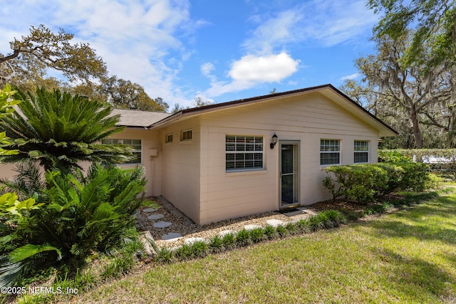 50 SE Forest St, Keystone Heights, FL 32656 - rear view of house featuring concrete block siding and a lawn