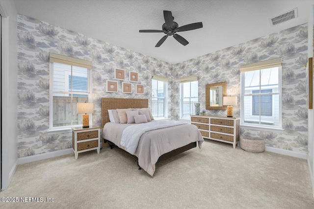 900 White St, Fernandina Beach, FL 32034 - carpeted bedroom with wallpapered walls, baseboards, multiple windows, a ceiling fan, and a textured ceiling