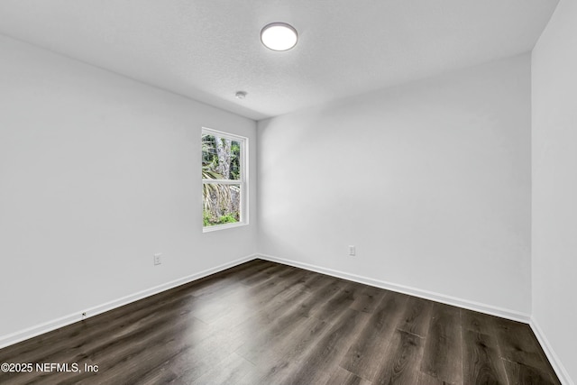 unfurnished room featuring baseboards, a textured ceiling, and dark wood finished floors