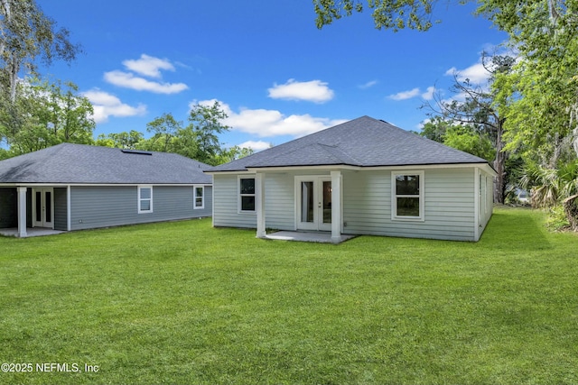 back of house with a yard, french doors, roof with shingles, and a patio area