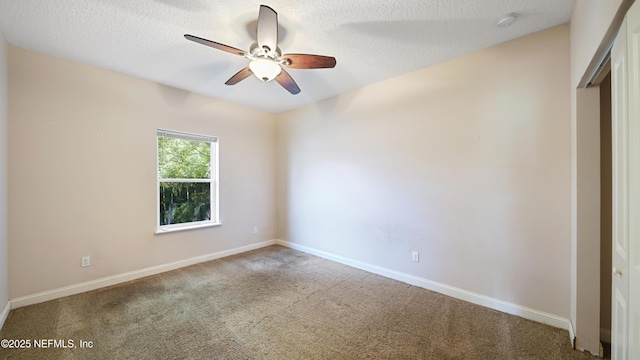 empty room with carpet floors, ceiling fan, baseboards, and a textured ceiling