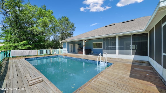 view of pool featuring a sunroom, a fenced in pool, and a deck