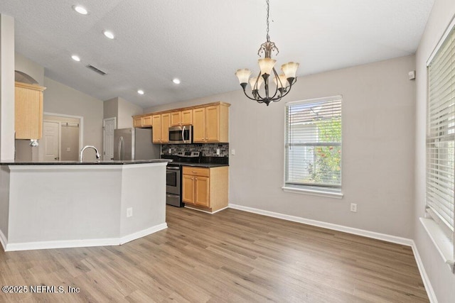 1029 Buttercup Dr, Saint Johns, FL 32259 - kitchen featuring stainless steel appliances, a chandelier, dark countertops, light wood-style flooring, and vaulted ceiling