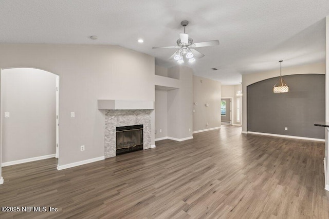 1029 Buttercup Dr, Saint Johns, FL 32259 - unfurnished living room featuring a ceiling fan, vaulted ceiling, wood finished floors, a tile fireplace, and baseboards