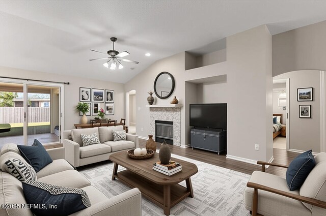 1029 Buttercup Dr, Saint Johns, FL 32259 - living area with arched walkways, ceiling fan, wood finished floors, lofted ceiling, and a glass covered fireplace