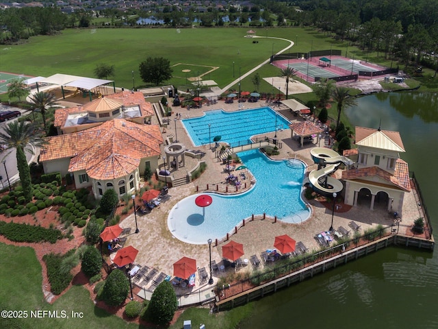 drone / aerial view of a pool area and a large body of water