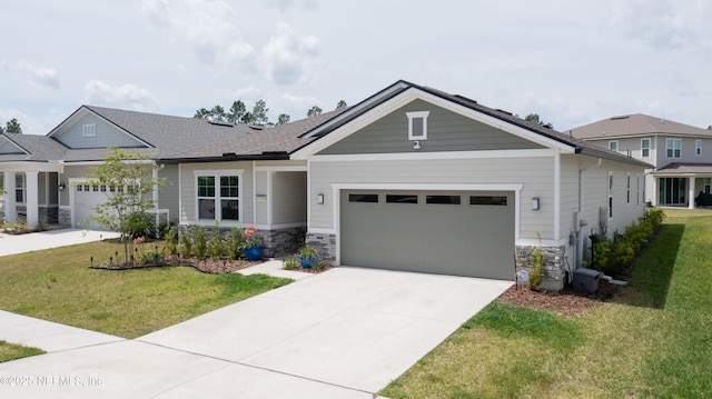 craftsman-style house featuring an attached garage, concrete driveway, a front yard, and stone siding