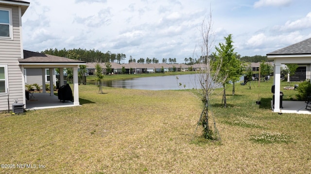 view of yard with a patio area, a residential view, and a water view