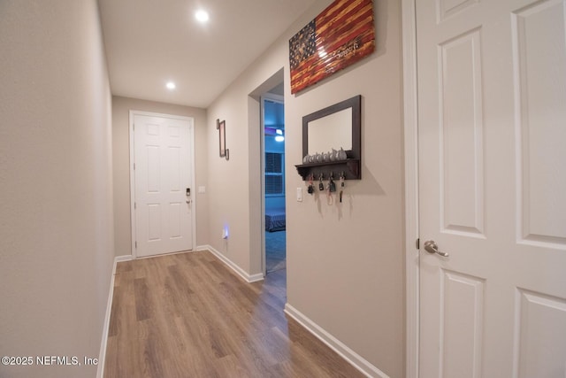 hallway with baseboards, recessed lighting, and wood finished floors