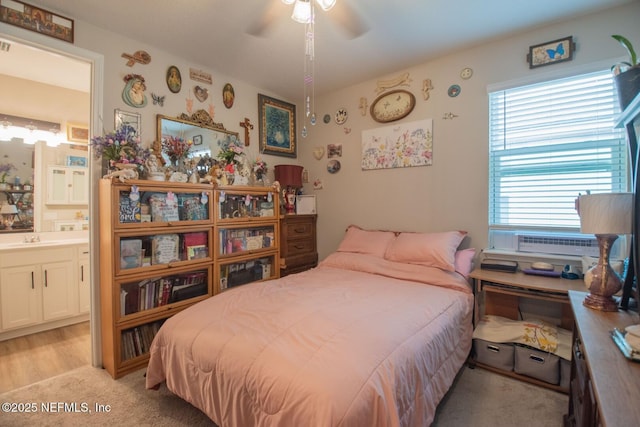 bedroom featuring a sink, a ceiling fan, and connected bathroom