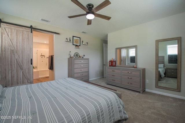 bedroom featuring visible vents, baseboards, a barn door, and carpet floors