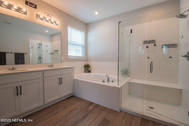 75309 White Rabbit Ave, Yulee, FL 32097 - bathroom featuring a shower stall, a garden tub, wood finished floors, double vanity, and recessed lighting