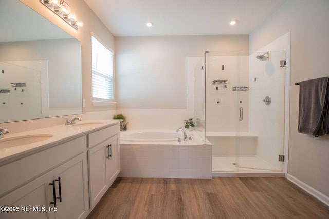 75309 White Rabbit Ave, Yulee, FL 32097 - bathroom featuring wood finished floors, a shower stall, a garden tub, and double vanity