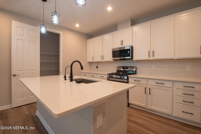 75309 White Rabbit Ave, Yulee, FL 32097 - kitchen with stainless steel appliances, dark wood-style floors, tasteful backsplash, white cabinetry, and decorative light fixtures