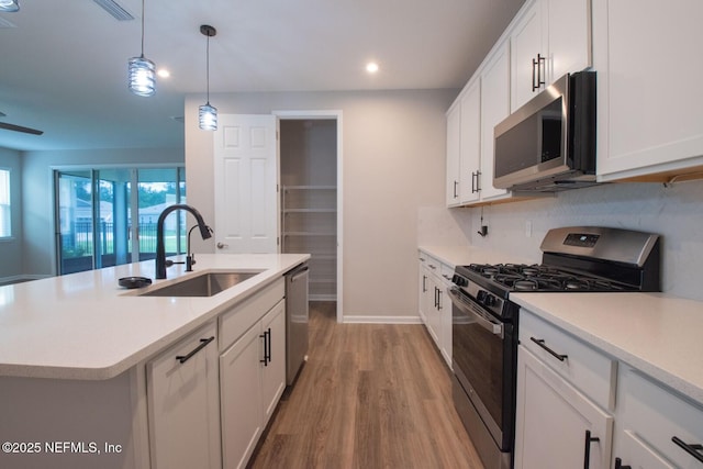 75309 White Rabbit Ave, Yulee, FL 32097 - kitchen with stainless steel appliances, light wood-type flooring, recessed lighting, light countertops, and white cabinetry