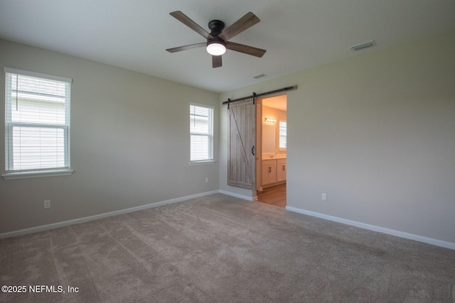 75309 White Rabbit Ave, Yulee, FL 32097 - spare room featuring a ceiling fan, carpet, and a barn door